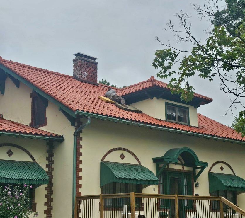 Ozark Bat Specialist performing exclusion work on a red tile roof